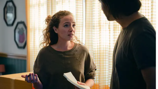 Two people talking at a table with an open notebook