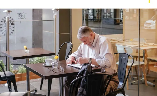 A man seated at a cafe table