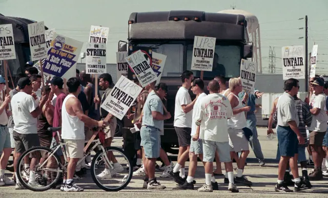 People gathered beside a bus with picket signs