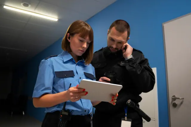 Two police officers are pictured looking over a recently made report