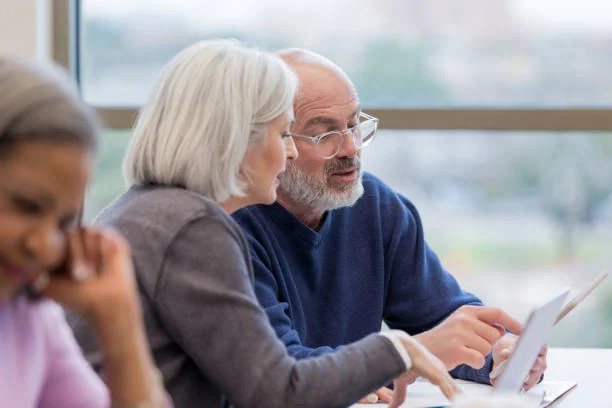 An older couple reviewing a laptop with another person