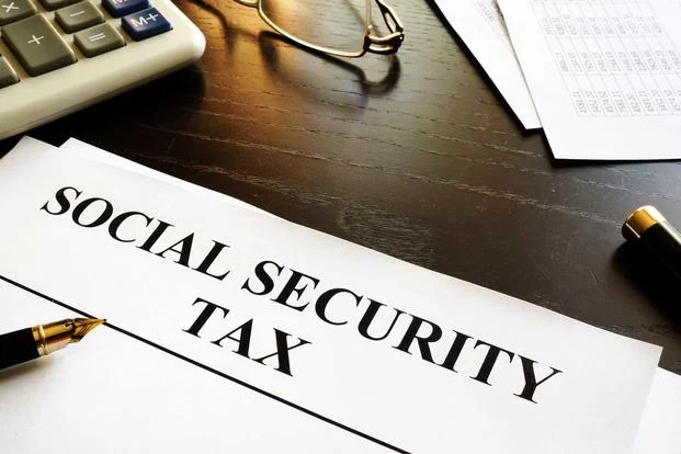 Paper labeled Social Security Tax beside a calculator
