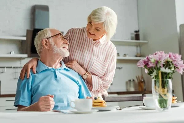 An older couple sitting together in a kitchen