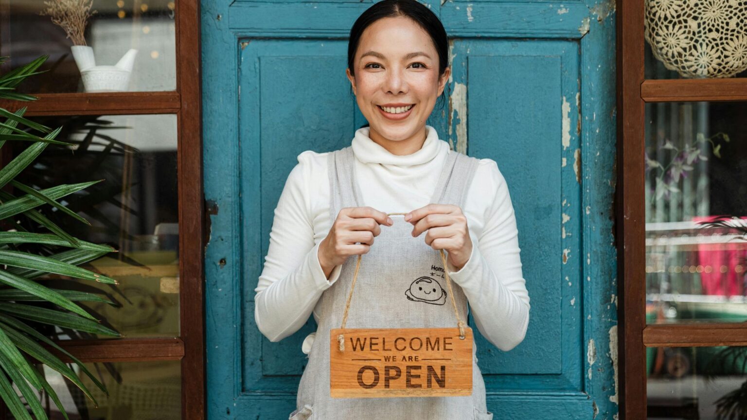 Business owner holding an "open" sign